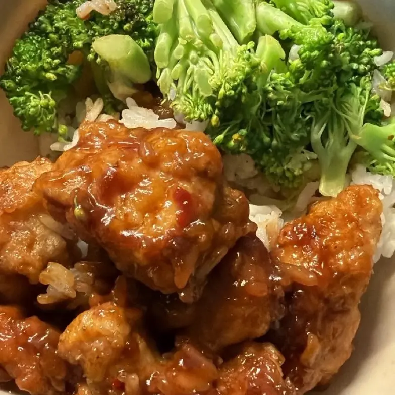 Orange chicken with steamed broccoli over white rice.
